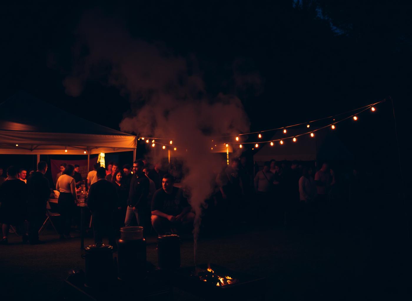 The Picnic Pit pop-up tent at dusk with smoker and string lights